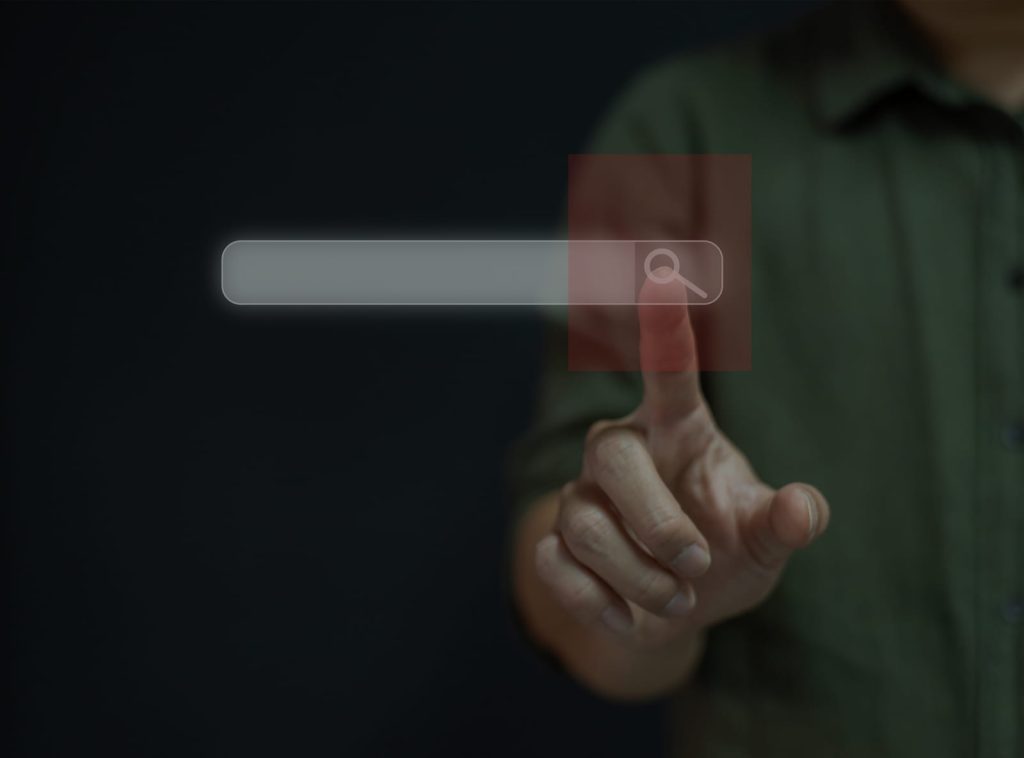 Scrittura SEO e intenzione di ricerca rappresentate da una barra di ricerca digitale e una mano che seleziona l’icona